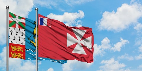 Saint Pierre And Miquelon and Wallis And Futuna flag waving in the wind against white cloudy blue sky together. Diplomacy concept, international relations.