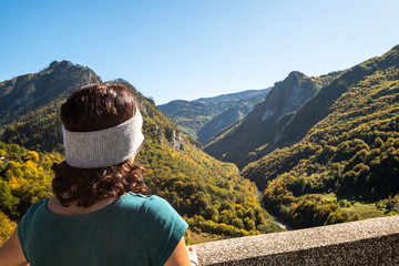 Beautiful lady in the durmitor national park looking over tara canyon and black lake during fall...