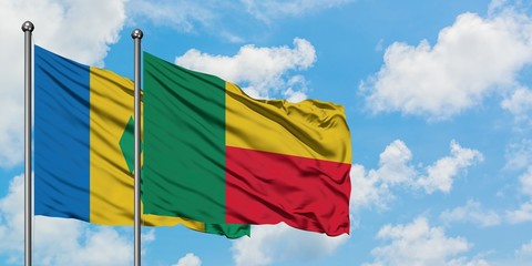 Saint Vincent And The Grenadines and Benin flag waving in the wind against white cloudy blue sky together. Diplomacy concept, international relations.