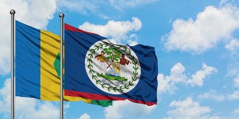 Saint Vincent And The Grenadines and Belize flag waving in the wind against white cloudy blue sky...