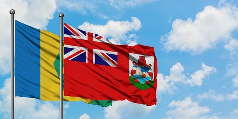 Saint Vincent And The Grenadines and Bermuda flag waving in the wind against white cloudy blue sky...
