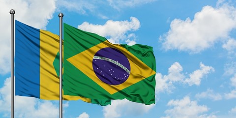 Saint Vincent And The Grenadines and Brazil flag waving in the wind against white cloudy blue sky...