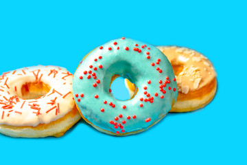 Set of assorted donuts with blue glaze, sprinkle, almond crumbs, chocolate and marshmallows close-up isolated on a purple background. Concept of sweet food (dessert). Copy space for text.