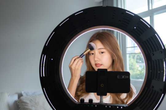 Portrait of young asian woman review giveaway gift product fan following channel, recording video make up lipstic cosmetic at home. Beauty blogger present beauty cosmetics
