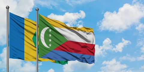 Saint Vincent And The Grenadines and Comoros flag waving in the wind against white cloudy blue sky...