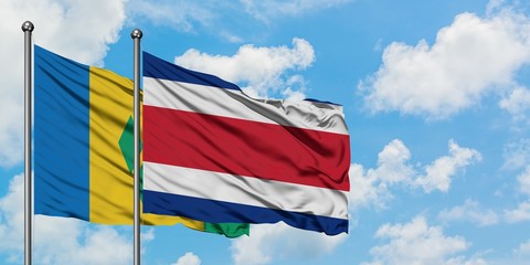 Saint Vincent And The Grenadines and Costa Rica flag waving in the wind against white cloudy blue sky together. Diplomacy concept, international relations.