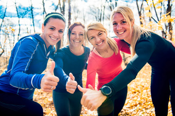 woman group out running together in an autumn park they run a race or train in a healthy outdoors...