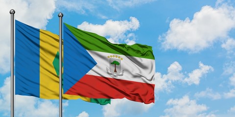 Saint Vincent And The Grenadines and Equatorial Guinea flag waving in the wind against white cloudy...