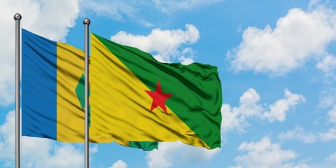 Saint Vincent And The Grenadines and French Guiana flag waving in the wind against white cloudy...