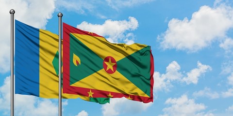 Saint Vincent And The Grenadines and Grenada flag waving in the wind against white cloudy blue sky...
