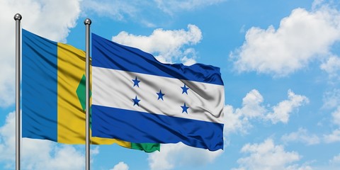 Saint Vincent And The Grenadines and Honduras flag waving in the wind against white cloudy blue sky together. Diplomacy concept, international relations.