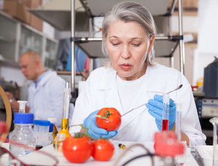Female geneticist conducting experiments with fruits and vegetables