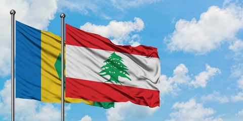 Saint Vincent And The Grenadines and Lebanon flag waving in the wind against white cloudy blue sky...