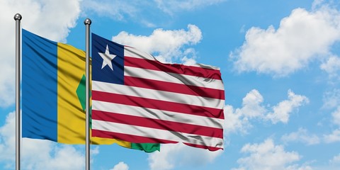 Saint Vincent And The Grenadines and Liberia flag waving in the wind against white cloudy blue sky together. Diplomacy concept, international relations.