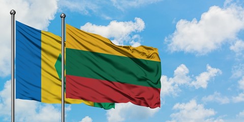 Saint Vincent And The Grenadines and Lithuania flag waving in the wind against white cloudy blue sky together. Diplomacy concept, international relations.