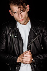 Plakat brutal man in leather jacket with clenched hands isolated on black