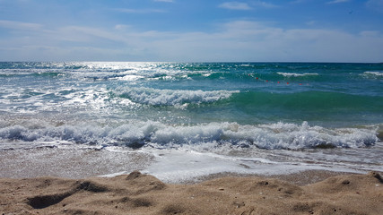 Beautiful waves on the beach. Waves on the sea on a Sunny day. The sea is agitated.