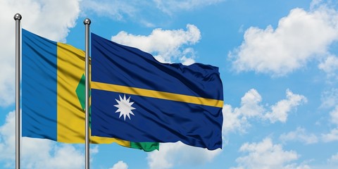 Saint Vincent And The Grenadines and Nauru flag waving in the wind against white cloudy blue sky...