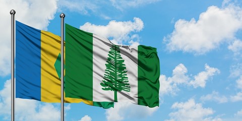 Saint Vincent And The Grenadines and Norfolk Island flag waving in the wind against white cloudy...