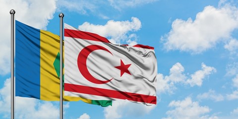 Saint Vincent And The Grenadines and Northern Cyprus flag waving in the wind against white cloudy...