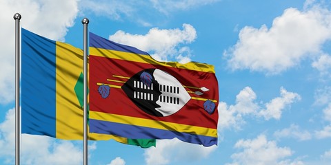 Saint Vincent And The Grenadines and Swaziland flag waving in the wind against white cloudy blue...