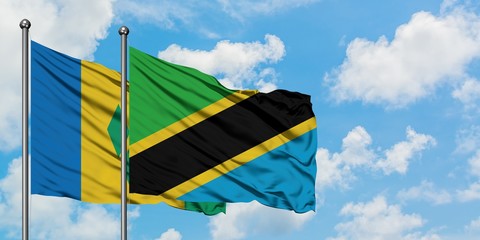 Saint Vincent And The Grenadines and Tanzania flag waving in the wind against white cloudy blue sky...