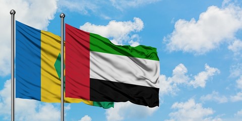 Saint Vincent And The Grenadines and United Arab Emirates flag waving in the wind against white cloudy blue sky together. Diplomacy concept, international relations.