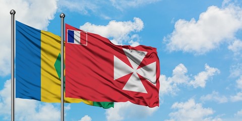 Saint Vincent And The Grenadines and Wallis And Futuna flag waving in the wind against white cloudy blue sky together. Diplomacy concept, international relations.