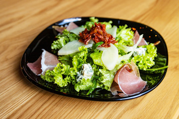 Salad with prosciutto and pear, blue cheese and sun-dried tomatoes
