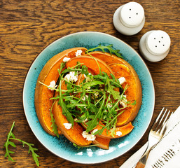 Baked pumpkin with feta and herbs. Selective focus