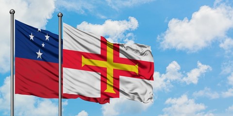 Samoa and Guernsey flag waving in the wind against white cloudy blue sky together. Diplomacy...