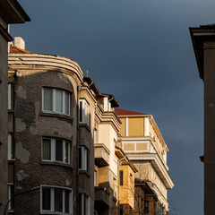 Fototapeta na wymiar buildings illuminated by the sun, with grey stormy sky