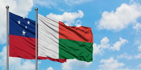Samoa and Madagascar flag waving in the wind against white cloudy blue sky together. Diplomacy concept, international relations.