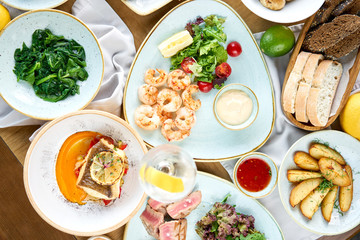Plates seafood BBQ with garnish. Variety of dishes on the table. Restaurant menu.