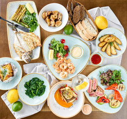 Plates seafood BBQ with garnish. Variety of dishes on the table. Restaurant menu.