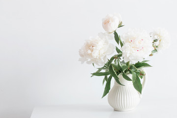 peonies flowers in vase on white background © Maya Kruchancova