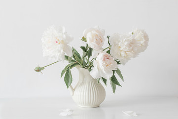 peonies flowers in vase on white background © Maya Kruchancova