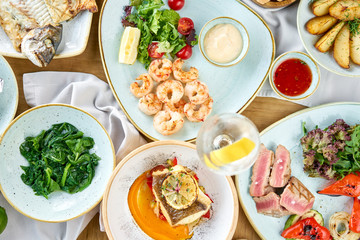Plates seafood BBQ with garnish. Variety of dishes on the table. Restaurant menu.