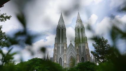 church-church surrounded by green trees shot taken from behind a bush 