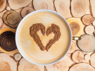 Heart shape, love symbol on hot white coffee, lover sign from cinnamon powder, on wooden surface