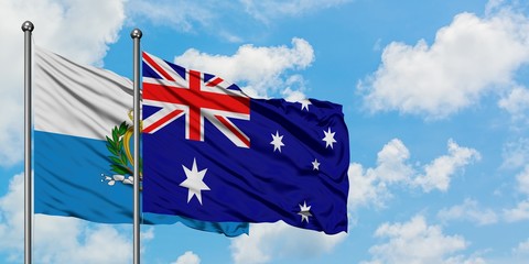 San Marino and Australia flag waving in the wind against white cloudy blue sky together. Diplomacy concept, international relations.