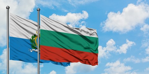 San Marino and Bulgaria flag waving in the wind against white cloudy blue sky together. Diplomacy...