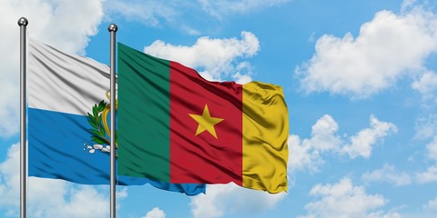 San Marino and Cameroon flag waving in the wind against white cloudy blue sky together. Diplomacy concept, international relations.