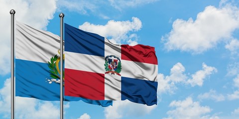 San Marino and Dominican Republic flag waving in the wind against white cloudy blue sky together....