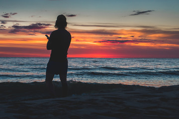 Fototapeta premium silhouette of a man on the beach at sunset