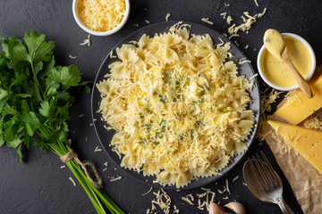 Tasty appetizing cooked italian farfalle pasta (bow-tie or butterfly) with with sauce and grated cheese. Top view.