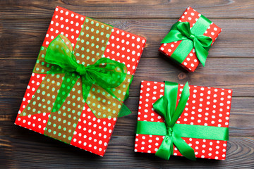 paper gift box with colored ribbon on dark wood background. top view with copy space Christmas...