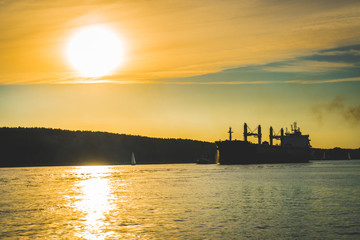 Naklejka premium cargo ship in sea at sunset