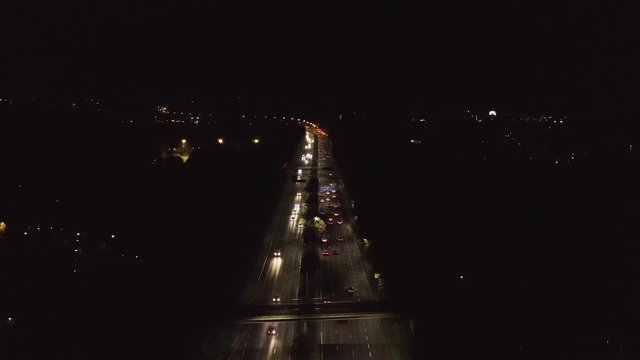 Aerial, drone shot, overlooking traffic, on highway Keha 1, on a dark, autumn night, in Espoo, Finland