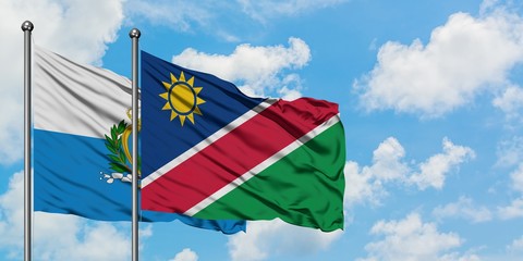 San Marino and Namibia flag waving in the wind against white cloudy blue sky together. Diplomacy concept, international relations.